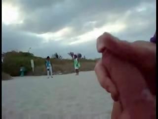 Amerikansk turist runkar på den strand medan kvinna passing av filma